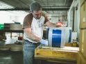 Brian sanding down a royal blue drum